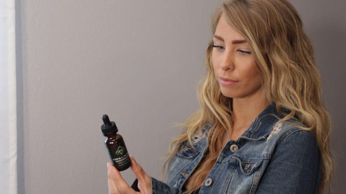 CBD-ישראל בחורה עם בקבוק שמן CBD